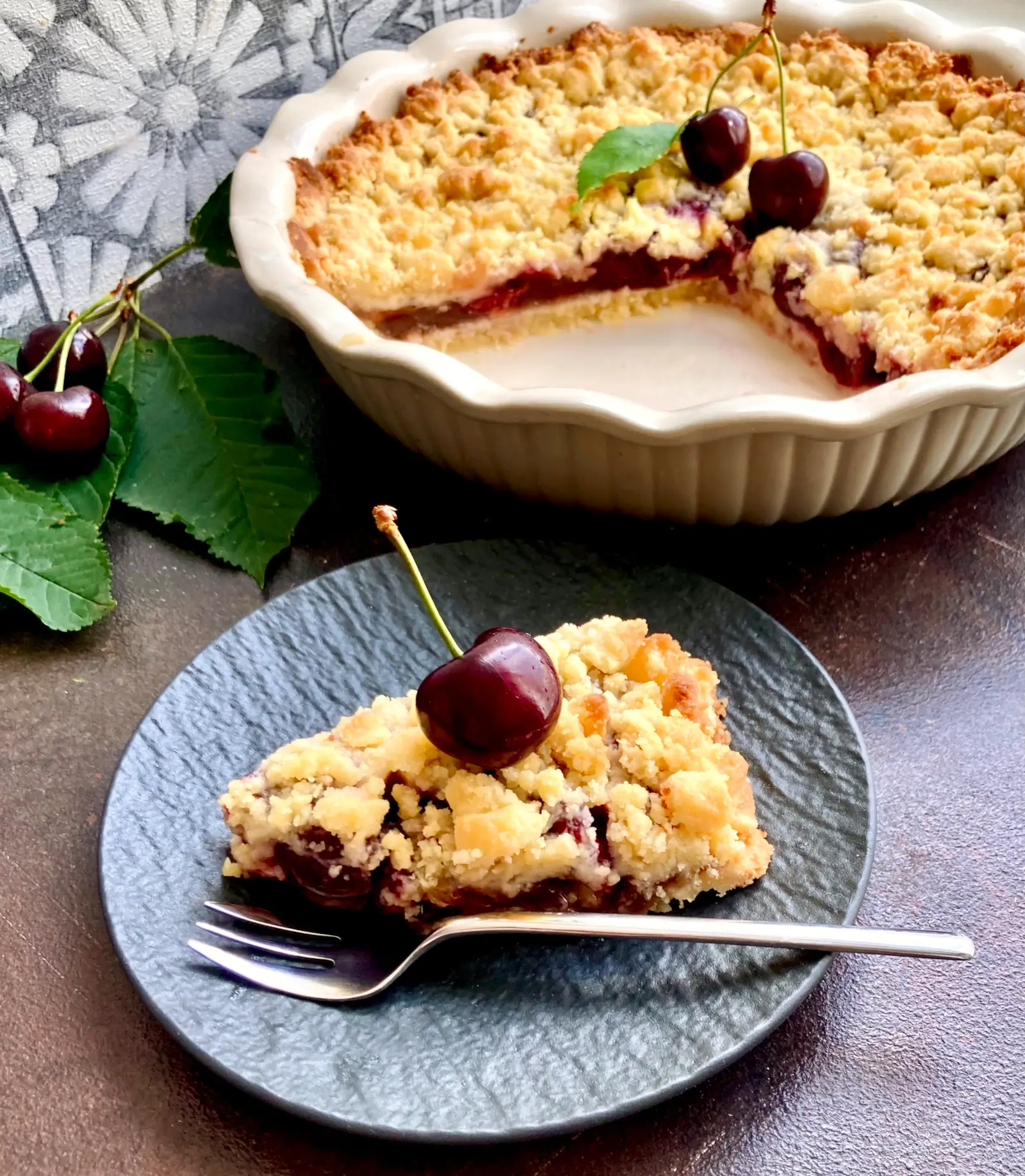 Kirsch Streuselkuchen auf Teller mit Kirsche als Topping